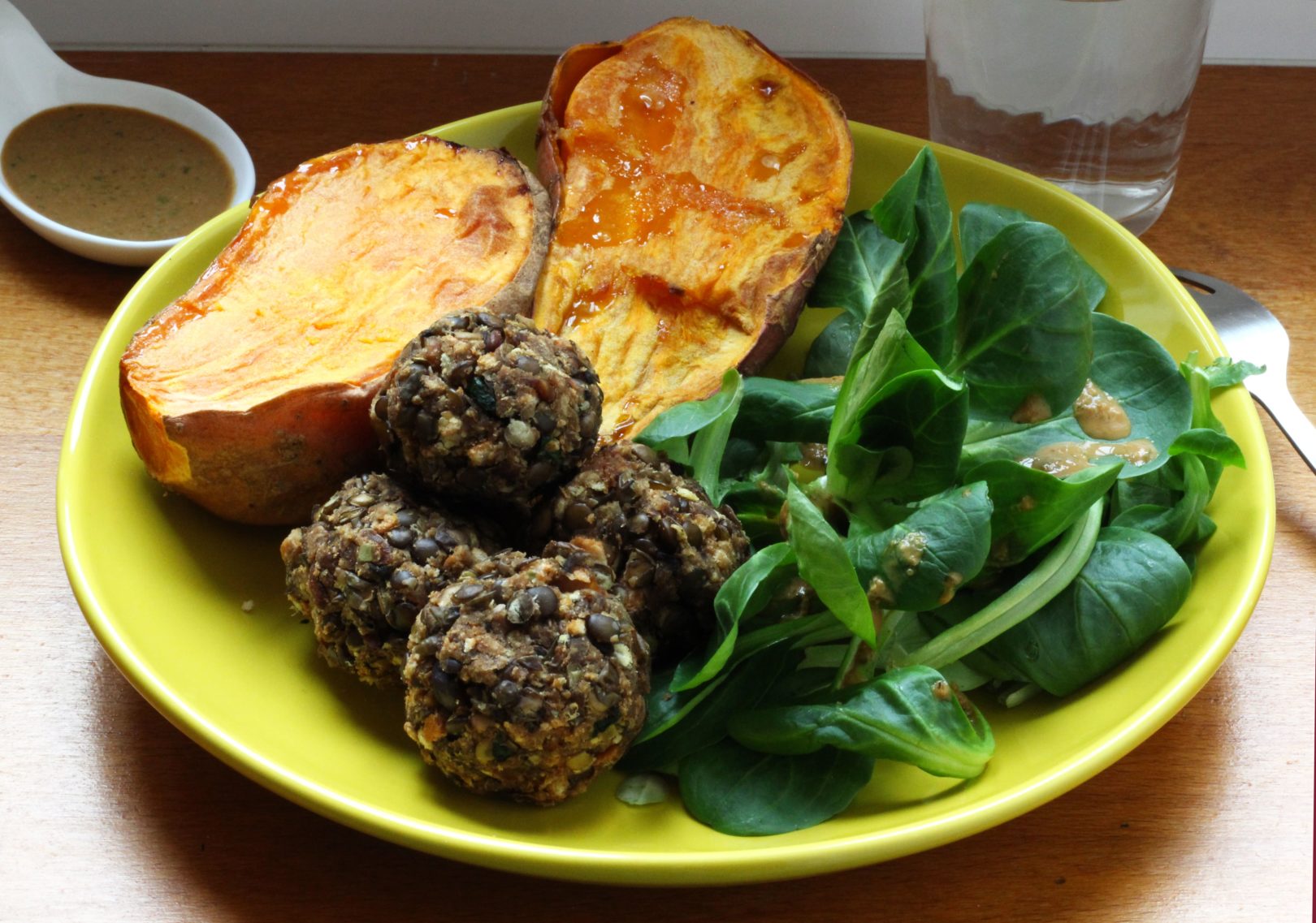 Boulettes de lentilles et patate douce rôtie accompagnés de mâche à la sauce cacahuète