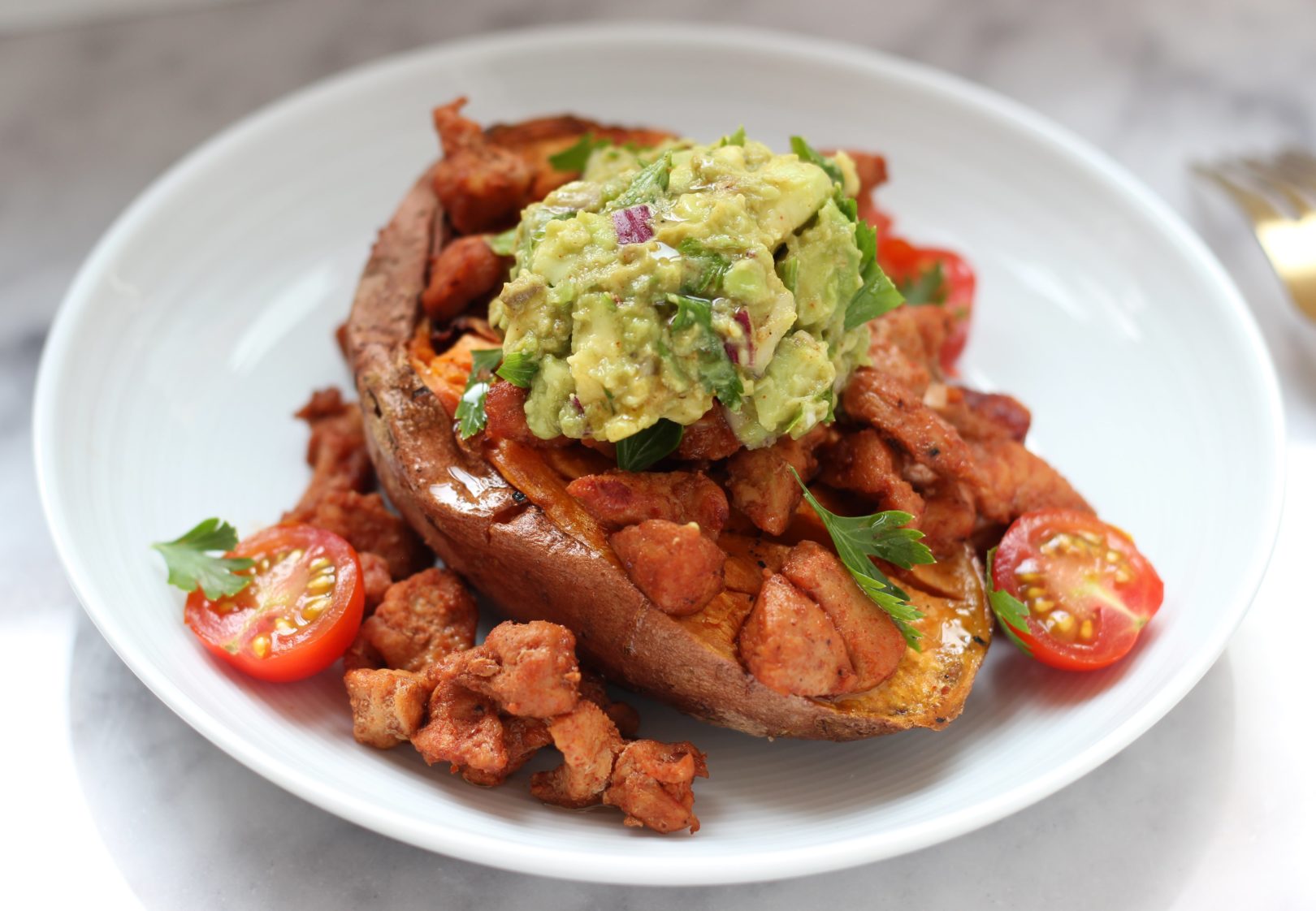 Patate douce rôtie au four accompagnée de guacamole et porc sauté au paprika